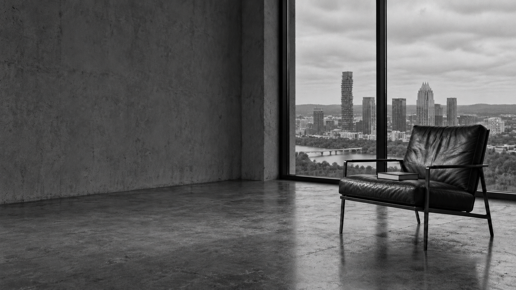 Empty lounge chair with a book, Austin skyline through the window